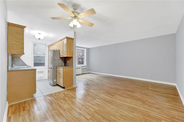 kitchen featuring sink, light hardwood / wood-style flooring, stainless steel refrigerator, ceiling fan, and light brown cabinets