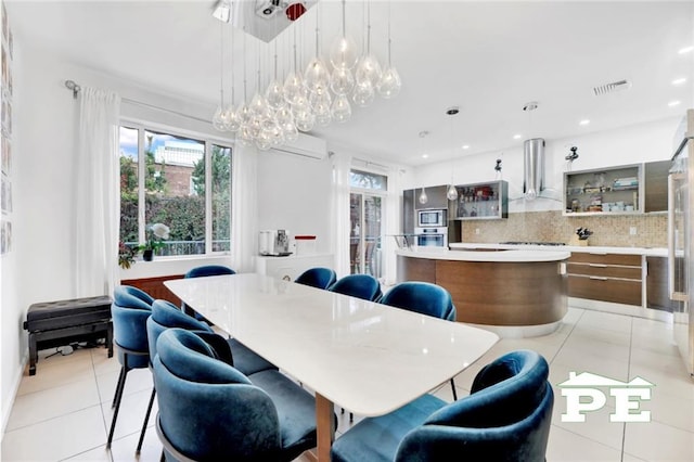 dining space featuring light tile patterned floors and a wall mounted air conditioner