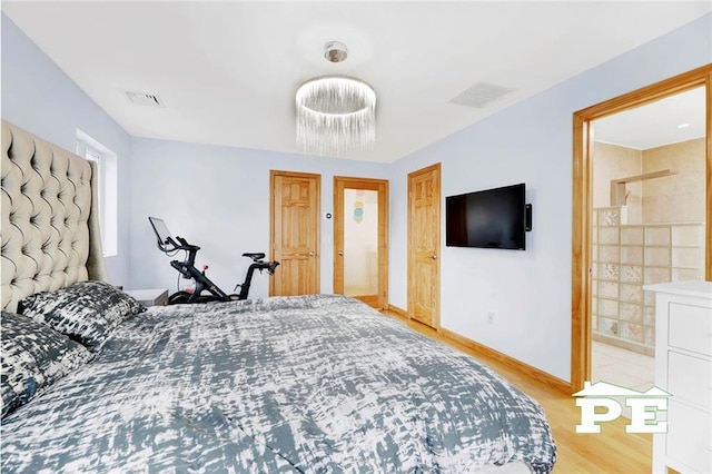 bedroom featuring light hardwood / wood-style floors and ensuite bath