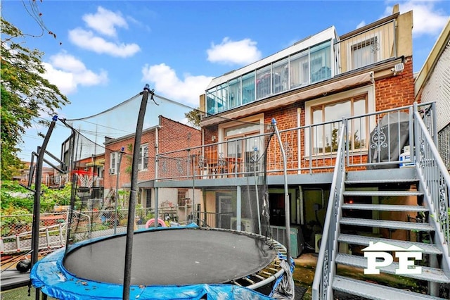 back of property featuring a trampoline