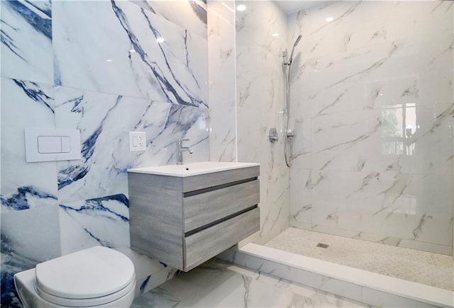 full bath with toilet, marble finish floor, a marble finish shower, and vanity