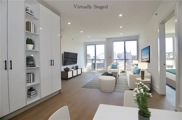 living room with light wood-type flooring and built in features