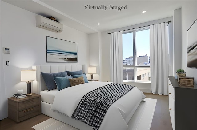 bedroom with a wall mounted air conditioner and hardwood / wood-style flooring