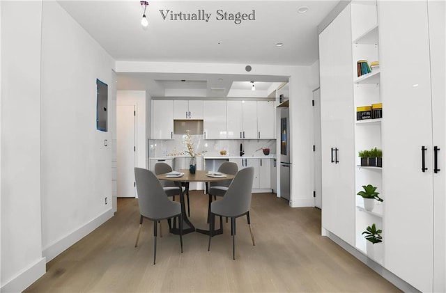 dining room with light wood-type flooring and baseboards