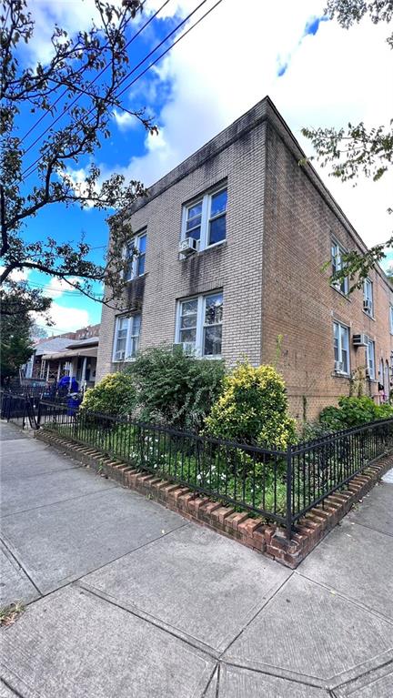 view of side of property with a fenced front yard and brick siding