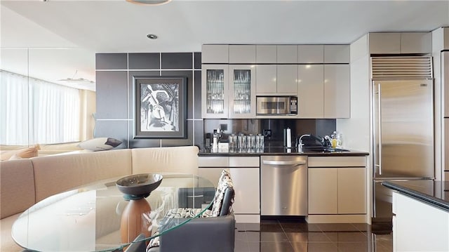 kitchen with sink, white cabinets, stainless steel appliances, and dark tile patterned flooring