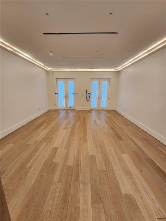 empty room featuring french doors and light hardwood / wood-style floors