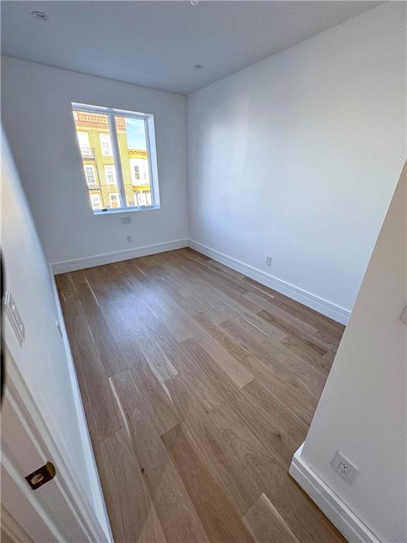 empty room with hardwood / wood-style flooring