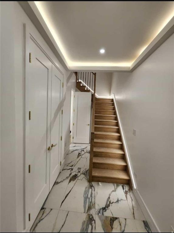 staircase featuring a tray ceiling