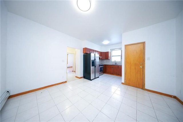 kitchen featuring sink, light tile patterned flooring, stainless steel fridge, baseboard heating, and range