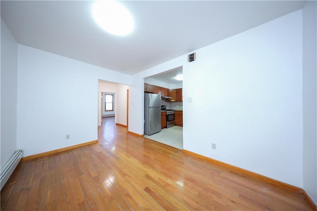 unfurnished room featuring light hardwood / wood-style flooring and a baseboard radiator