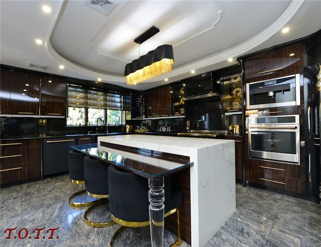 kitchen with dishwasher, sink, hanging light fixtures, a tray ceiling, and a kitchen island