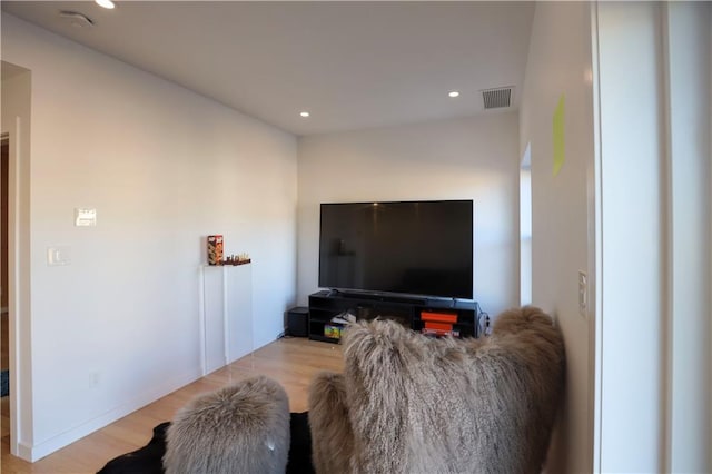 living area with recessed lighting, visible vents, and light wood finished floors