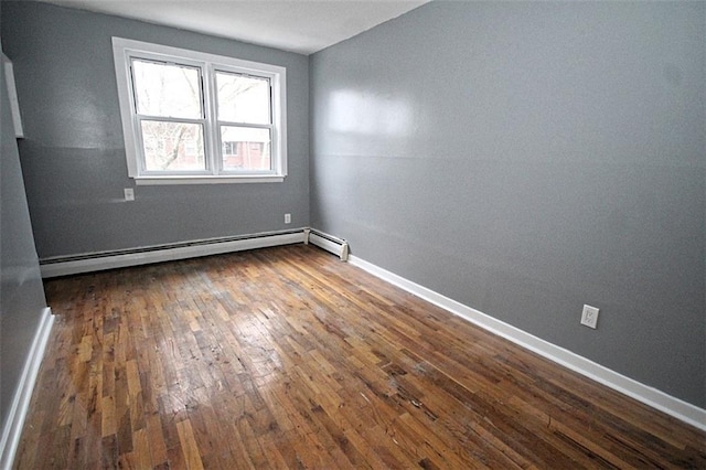 spare room with dark hardwood / wood-style flooring and baseboard heating