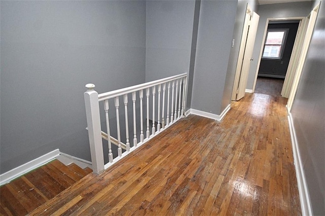 corridor with hardwood / wood-style floors and a baseboard radiator