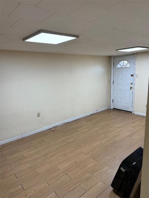 basement with light hardwood / wood-style flooring