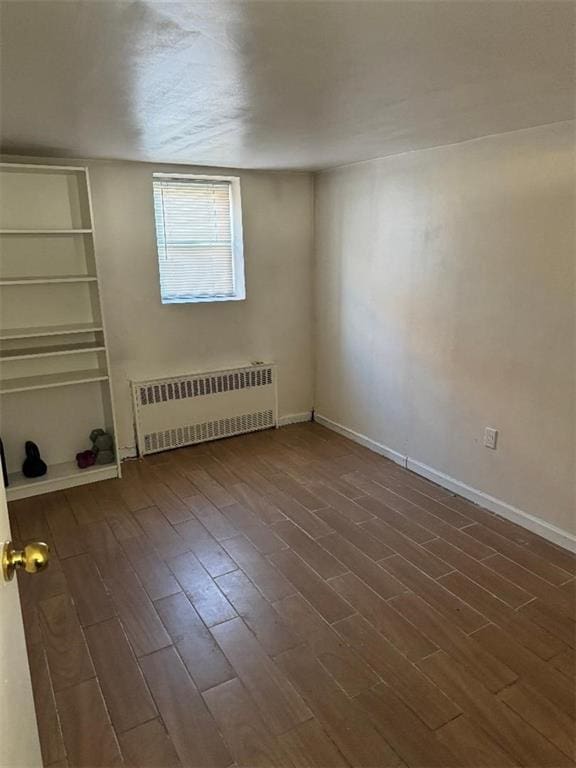 empty room with radiator and dark hardwood / wood-style flooring