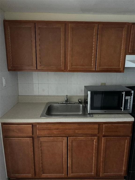 kitchen with ventilation hood, sink, and backsplash