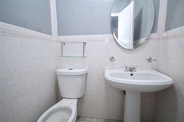 bathroom with tile walls and toilet