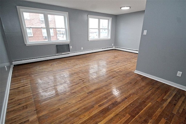 unfurnished room featuring a baseboard radiator and dark hardwood / wood-style floors