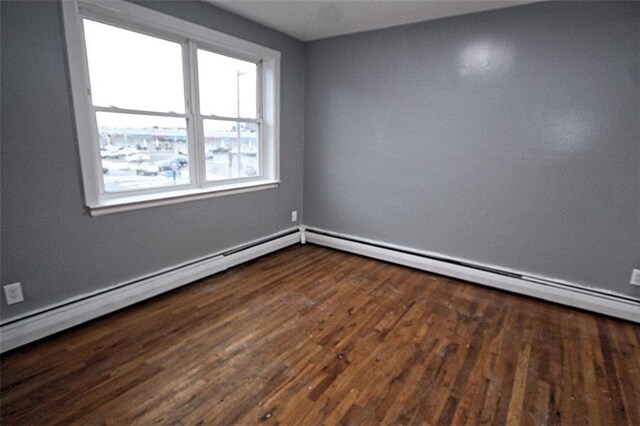 unfurnished room with a baseboard radiator and dark wood-type flooring