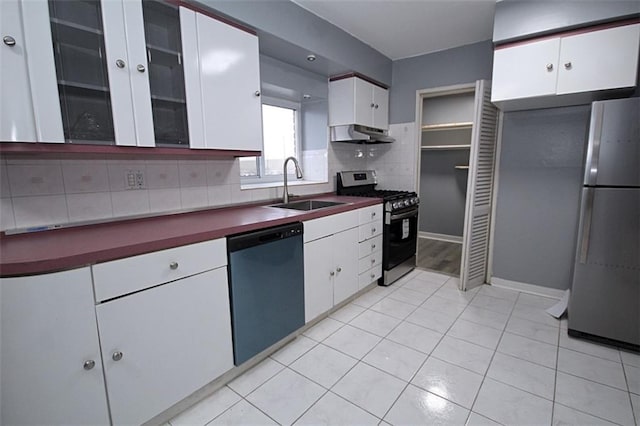 kitchen featuring stainless steel appliances, white cabinetry, sink, and backsplash