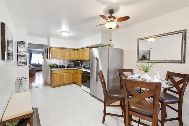 kitchen with ceiling fan, stainless steel appliances, light countertops, tasteful backsplash, and brown cabinets