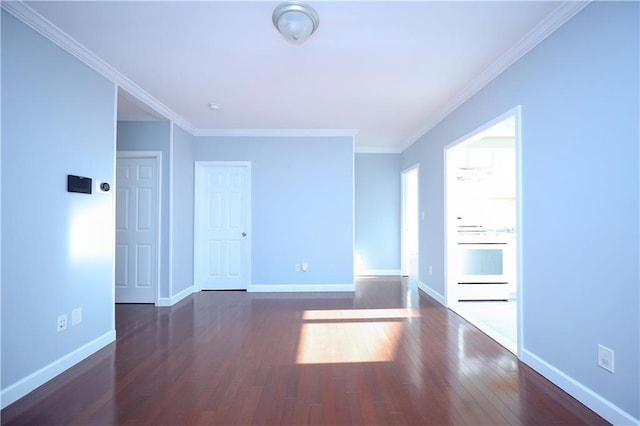 unfurnished room featuring baseboards, wood finished floors, and crown molding