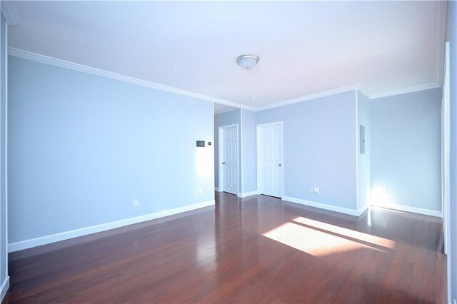 unfurnished room with baseboards, wood finished floors, and crown molding