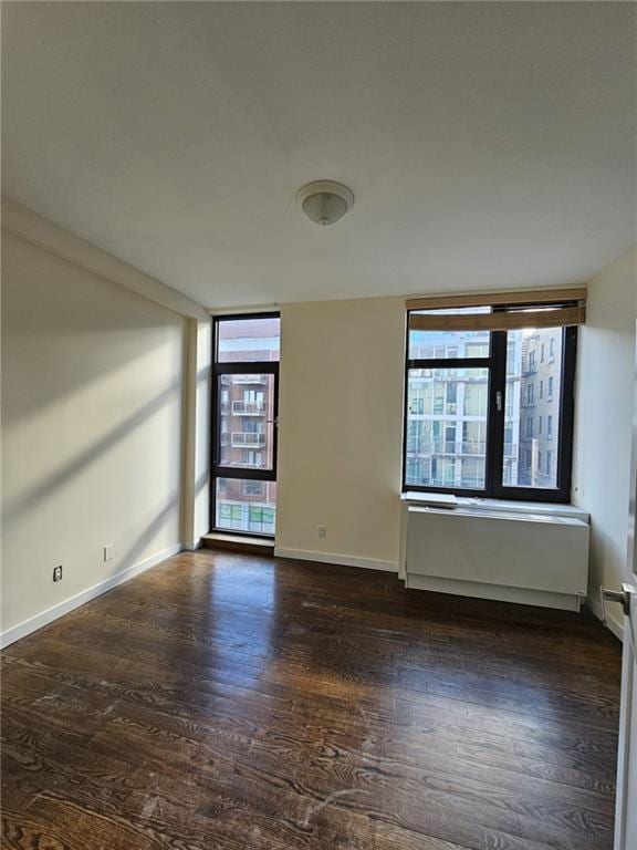 empty room with wood finished floors and baseboards