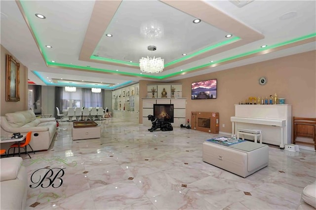 living room with a tray ceiling and a chandelier