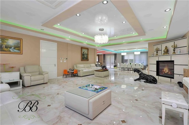 living room featuring a raised ceiling and a chandelier