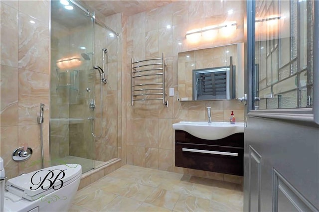 bathroom featuring vanity, a shower with door, tile walls, and radiator