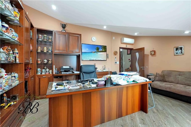 office space with lofted ceiling, a wall mounted AC, and light hardwood / wood-style flooring