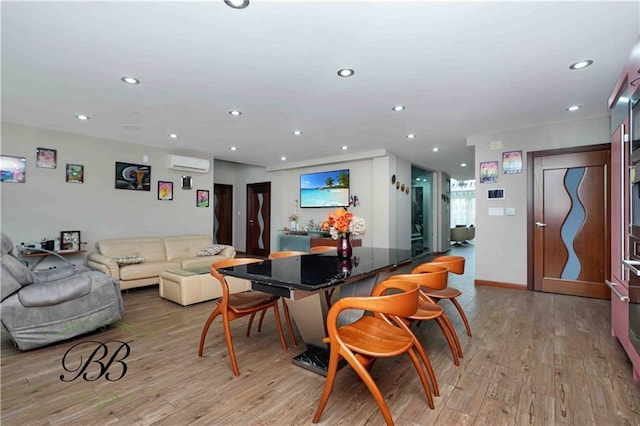 dining area with an AC wall unit and light hardwood / wood-style flooring