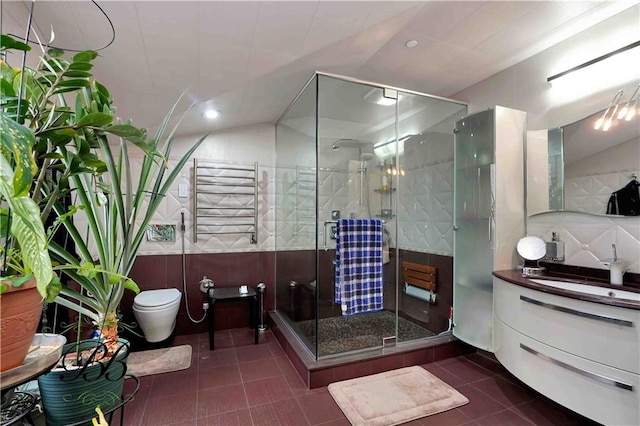 bathroom with vanity, tile patterned floors, toilet, an enclosed shower, and radiator heating unit