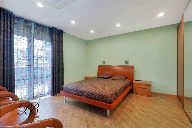 bedroom featuring multiple windows and light hardwood / wood-style flooring