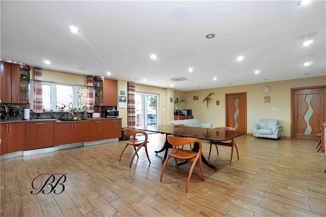 dining area with light hardwood / wood-style flooring and sink