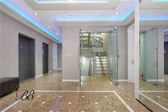 interior space featuring a tray ceiling and elevator