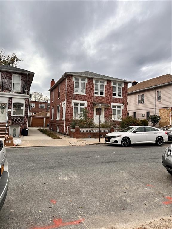 multi unit property with ac unit, brick siding, and a residential view