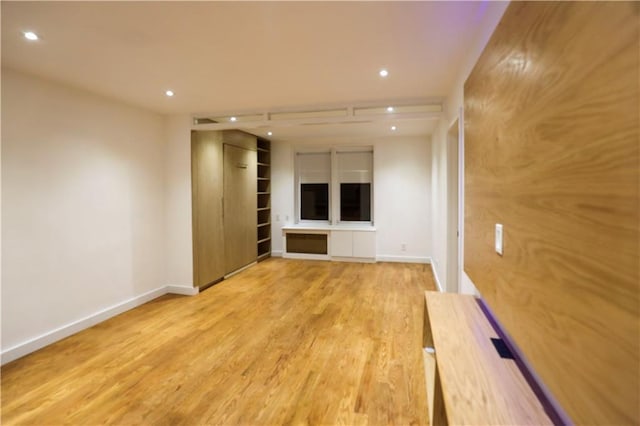 unfurnished living room with recessed lighting, baseboards, and light wood-style floors