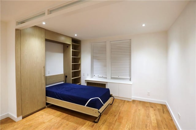 bedroom featuring recessed lighting, baseboards, light wood-style flooring, and radiator heating unit