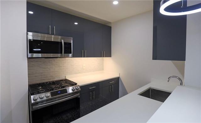 kitchen featuring a sink, dark cabinets, backsplash, and stainless steel appliances