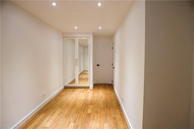 hallway with recessed lighting, baseboards, and light wood-style flooring