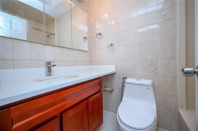 bathroom featuring vanity, toilet, tile walls, and a shower