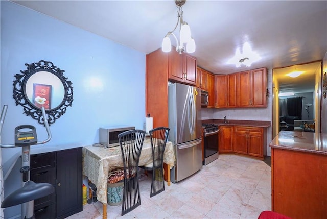 kitchen with appliances with stainless steel finishes and pendant lighting