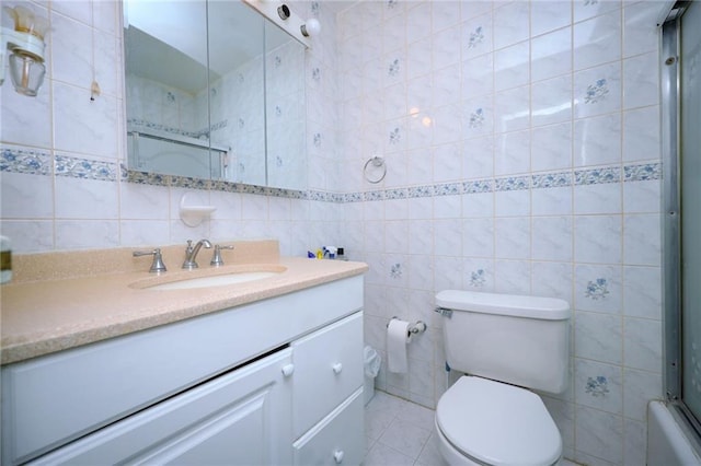 full bathroom featuring bath / shower combo with glass door, tile walls, tile patterned flooring, vanity, and toilet