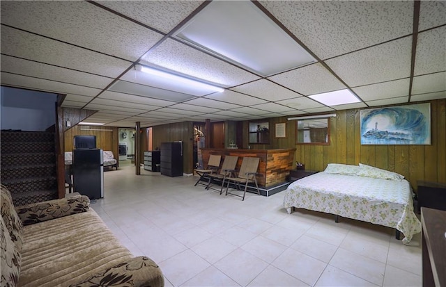 bedroom with wooden walls and a paneled ceiling