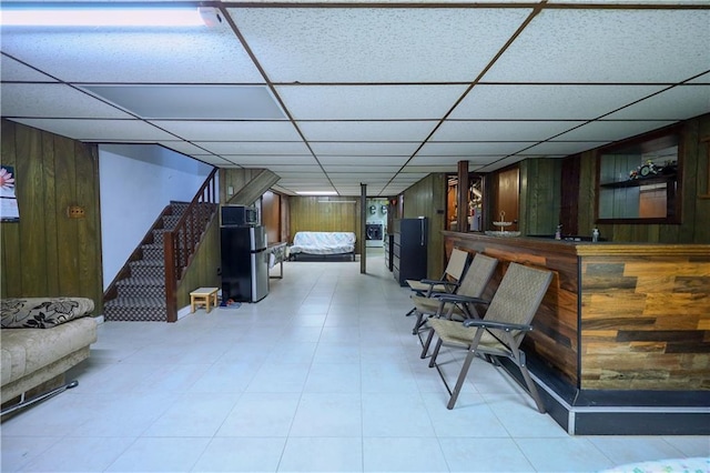 bar featuring a paneled ceiling and wood walls