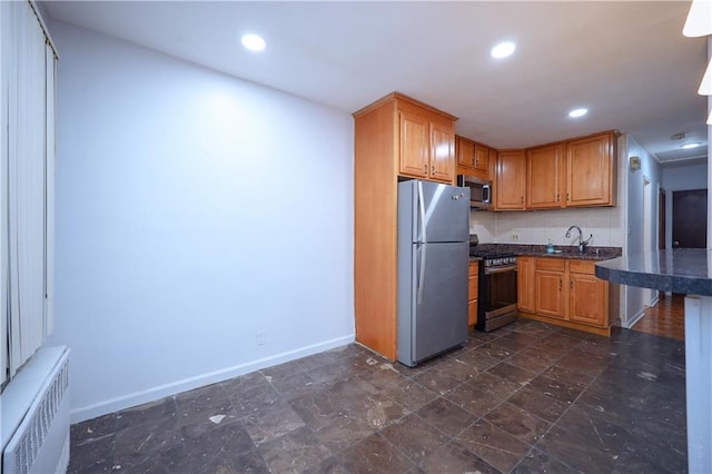 kitchen with sink, radiator heating unit, and appliances with stainless steel finishes